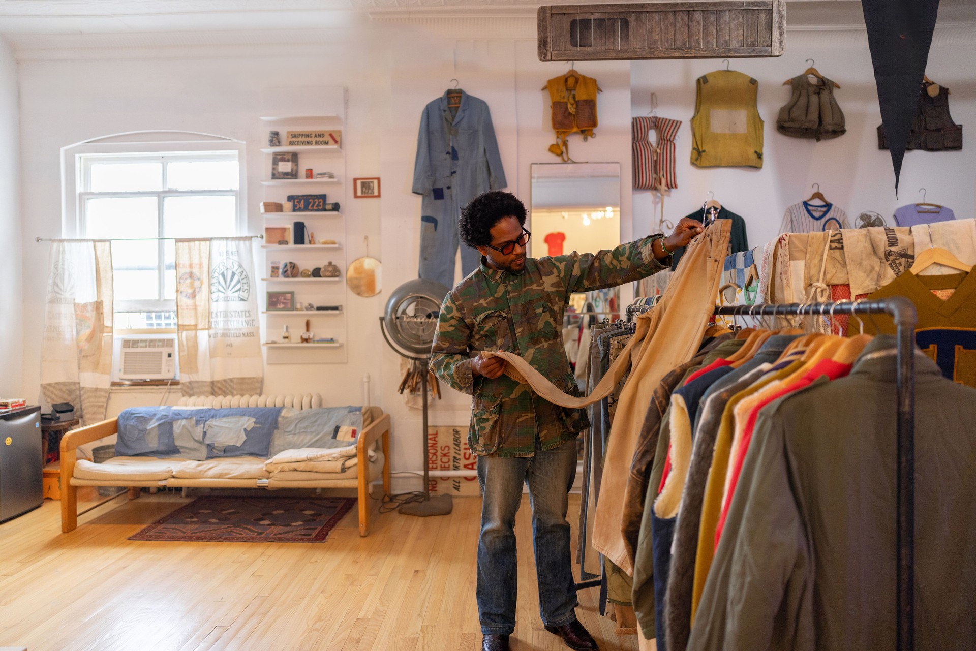 Small business owner examining vintage clothes in his shop